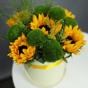 Композиция в шляпной коробке из подсолнухов и диантусов люкс в Ступино